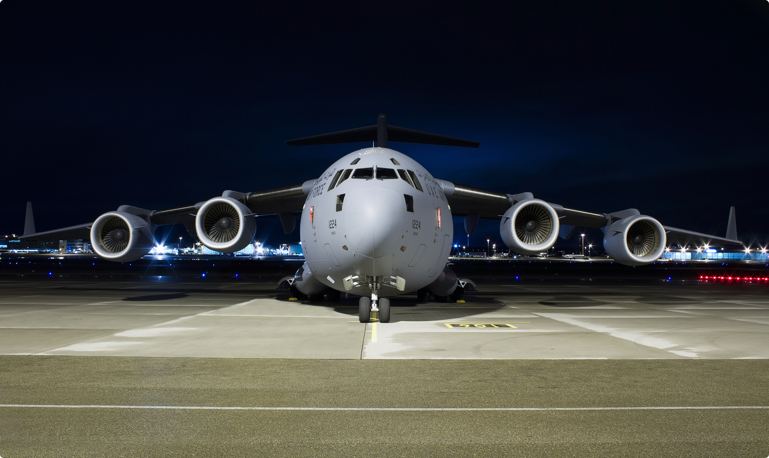 Military transport aircraft on a runway at night