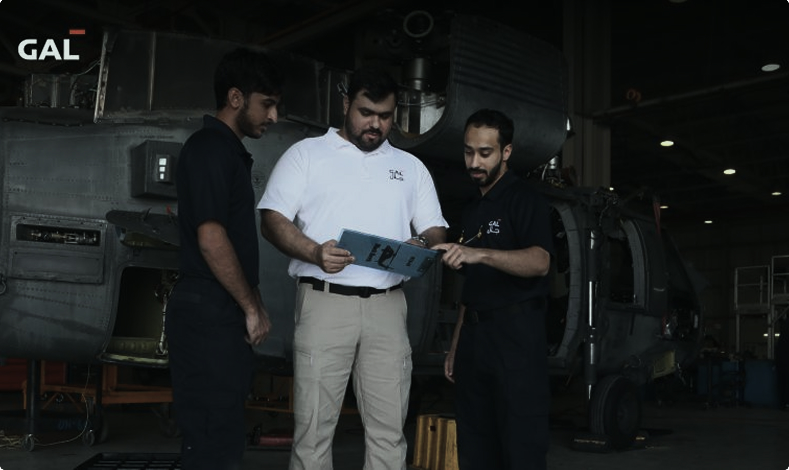GAL aviation specialists reviewing technical material in a hangar