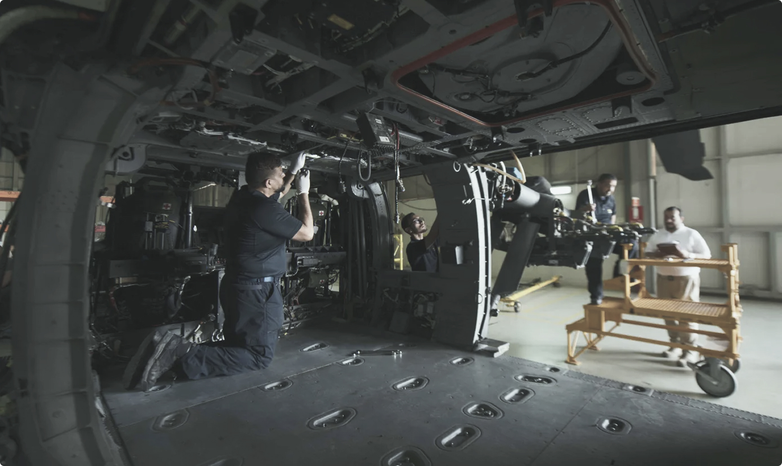 Aircraft technicians working inside a helicopter in a hangar